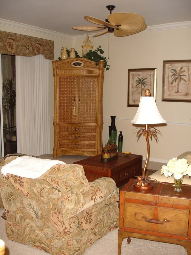 The comfortable living room includes a sofa, chairs, end tables, ceiling fa