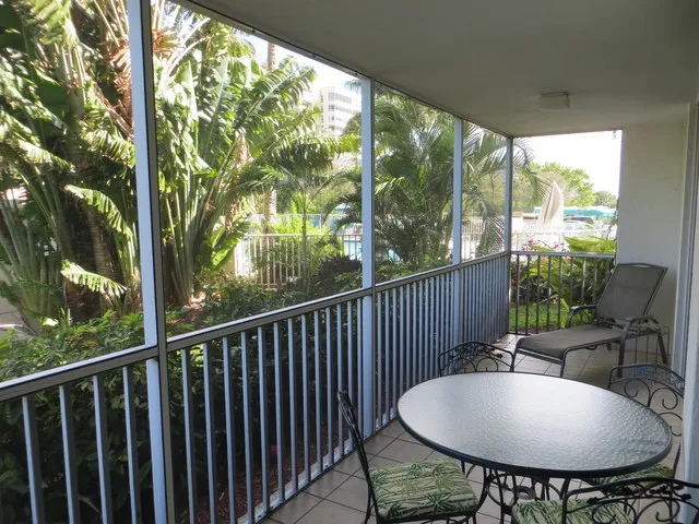 Large lanai with table and 4 chairs and chaise lounge looking to the pool.