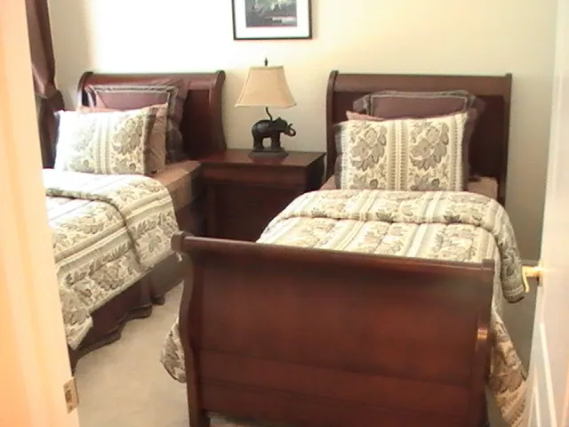 Third bedroom with twin solid wood beds, designer bedding and two closets