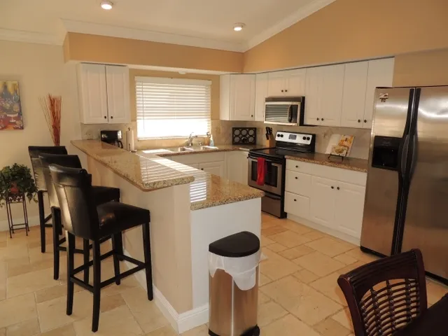 Fully equipped kitchen with stainless steel appliances and breakfast bar