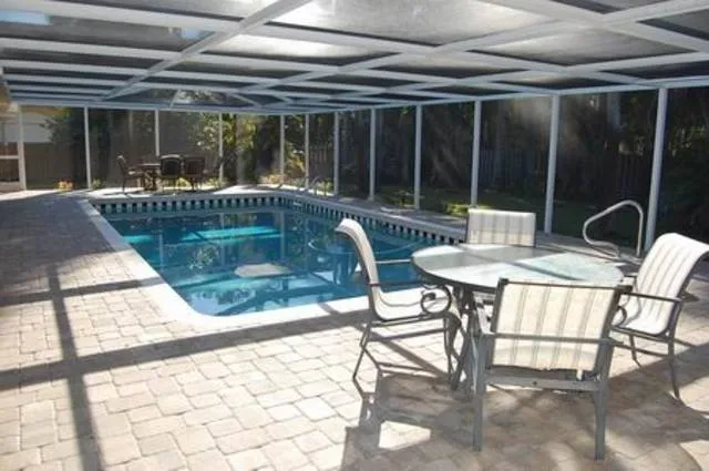 Sparkling pool with screened lanai and outdoor dining space