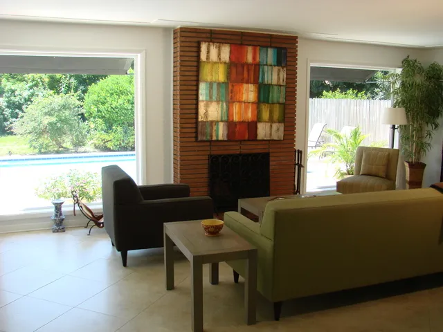 Living room features a flat screen tv & picture windows to the pool