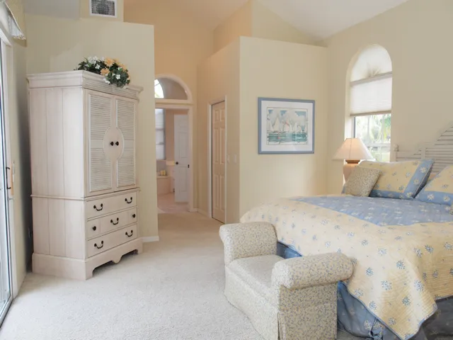 Large master suite with vaulted ceilings and sliding doors to the pool.