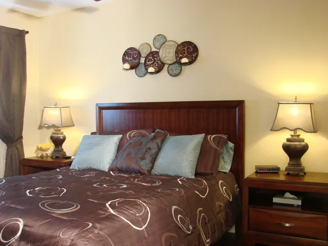 #104 bedroom features a queen bed, tv, custom closet & hardwood floors