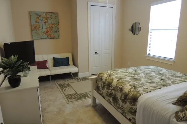 The guest room 1 has a queen bed with flat screen tv and a futon