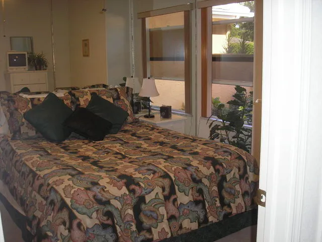 Guest bedroom with bureau and night stand,double closet overlooks courtyard