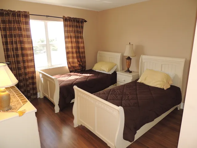The guest room has hardwood floors and twin beds