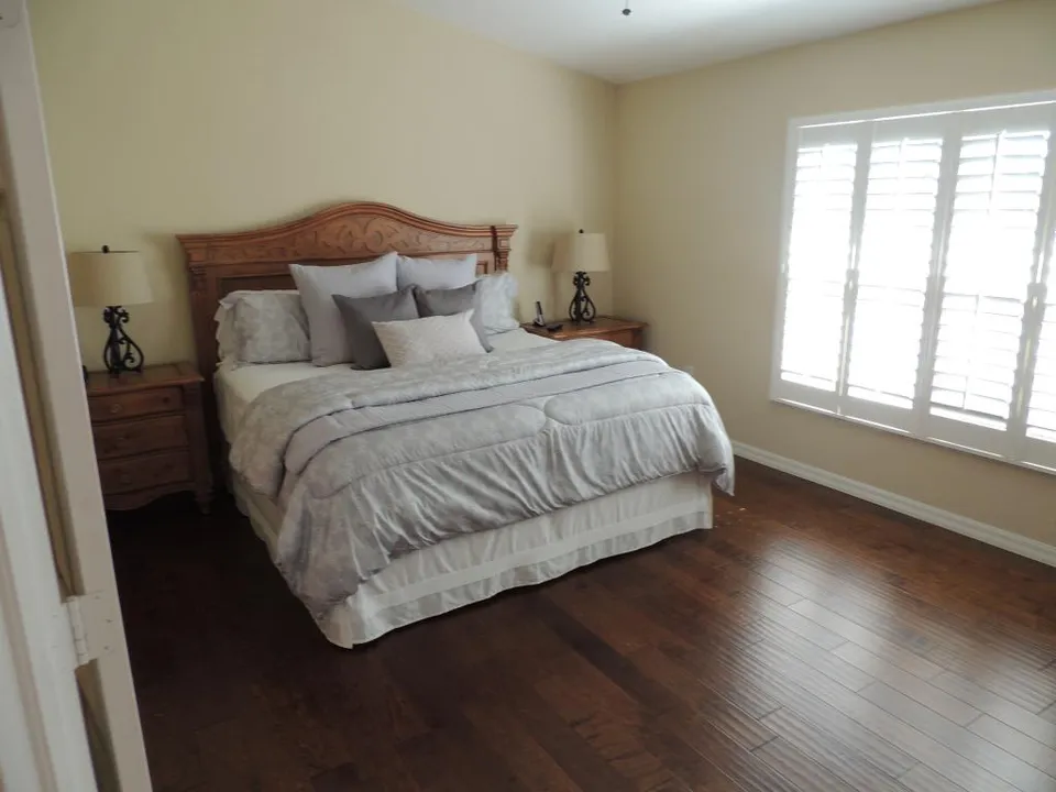 Master suite features hardwood flooring, king bed, walk in closet & private bath