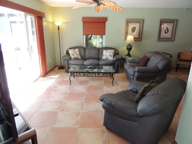 The living room has a leather seating and views of pool