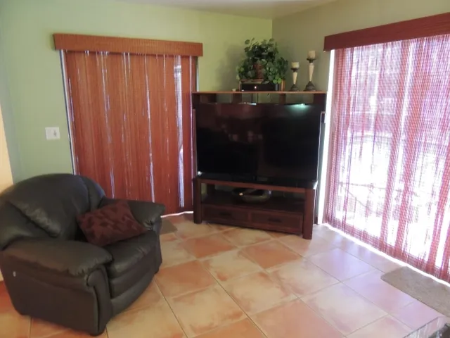 The living room has sliding glass doors leading to the pool area, a flat screen tv & wifi included