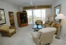 Spacious living room adjacent to lanai and overlooking waterfall pool.