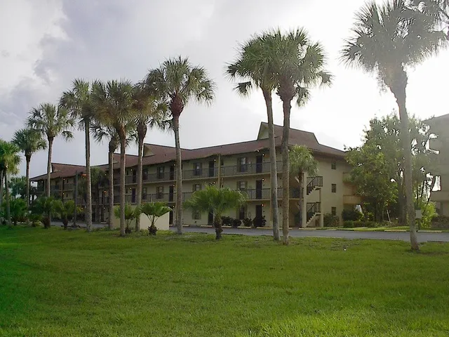 AN OUTSIDE VIEW OF MY BLDG W/ LOTS OF OPEN PARKING & A GRASSY PLAYING AREA