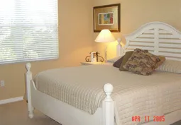 King size pillow top bed in master bedroom with TV and amoire