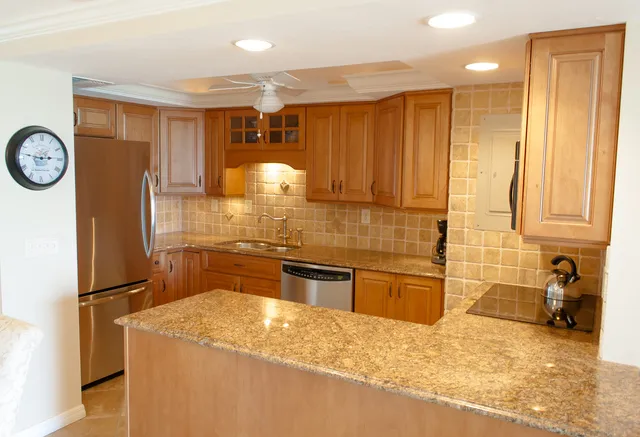 Granite countertops and tumbled stone tile work in the gourmet kitchen