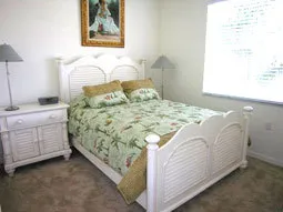 Sunny guest bedroom with large armoire and television. Queen sized bed.