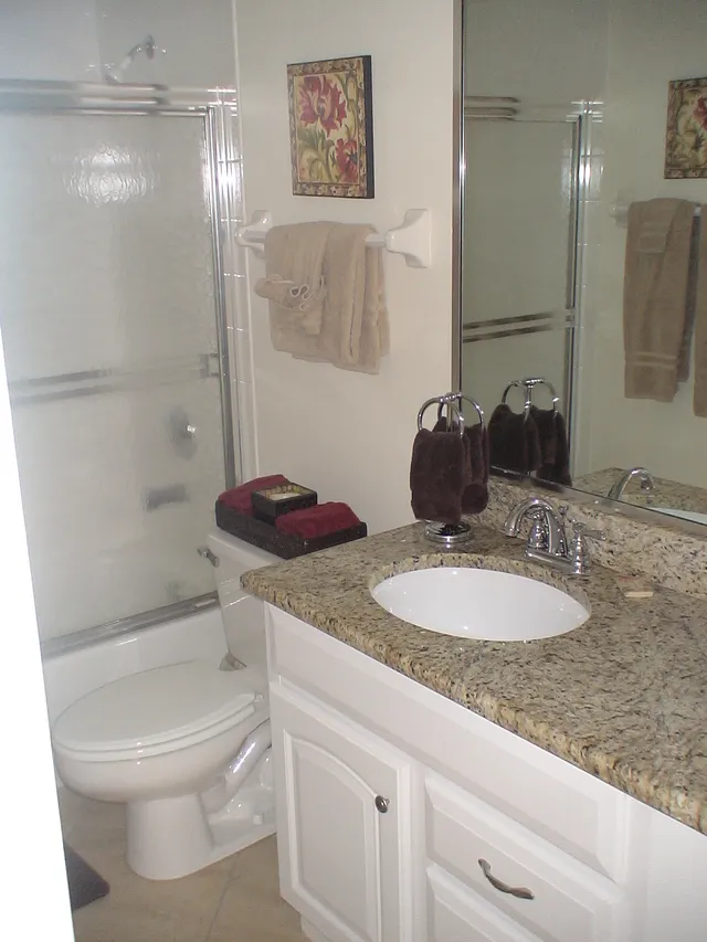 Guest bath features full-size tub/shower & granite counters.