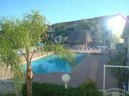 Pool, spa and tiki bar as viewed from liv. rm, bedrooms, and screened lanai