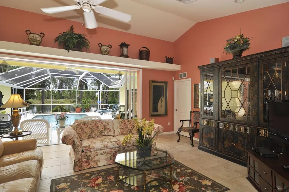 Livingroom reflects our love for Chinoiserie decor including Asian artifacts and a large laquered breakfront. The sliding glass doors pocket back to create a totally open wall to the lanai.