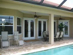 Covered lanai with outdoor table & chairs and chaise lounges.
