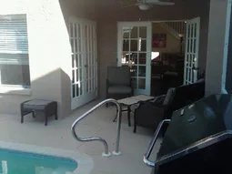 Pool, relaxing outdoor sitting area and grilling area all under large lanai