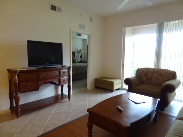 Large flat screen TV in living area with sliding doors out to lanai.