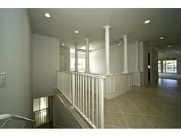 View from stairwell into dining room and hallway to kitchen and living area