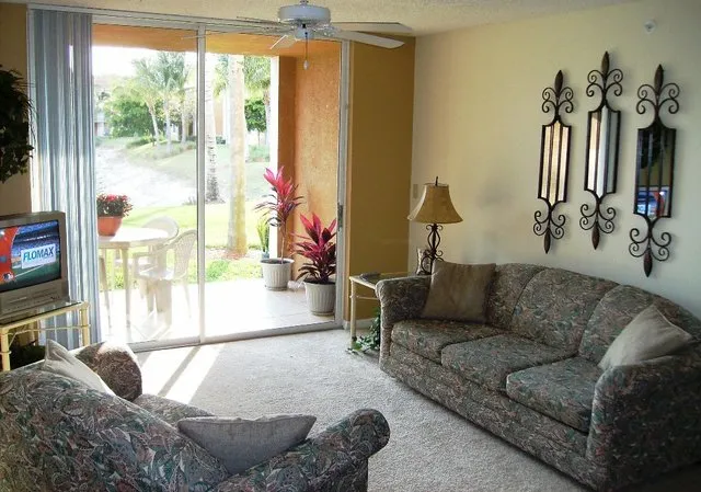 Cozy livingroom looks out to the lanai, lake, water fountains, and sunsets!